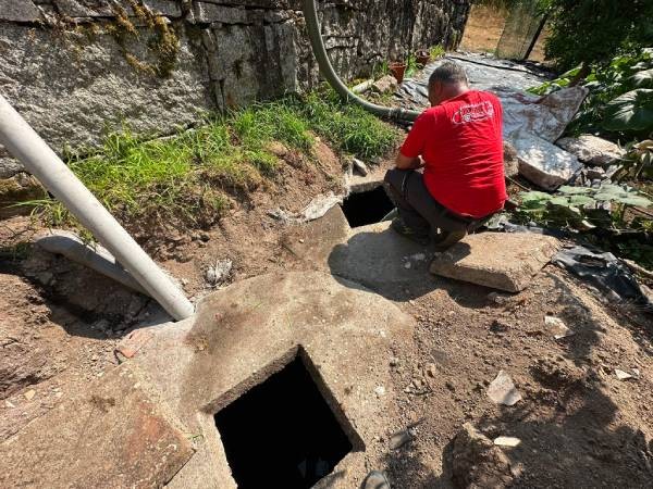 técnico de Desatascos Total trabajando junto a las arquetas abiertas